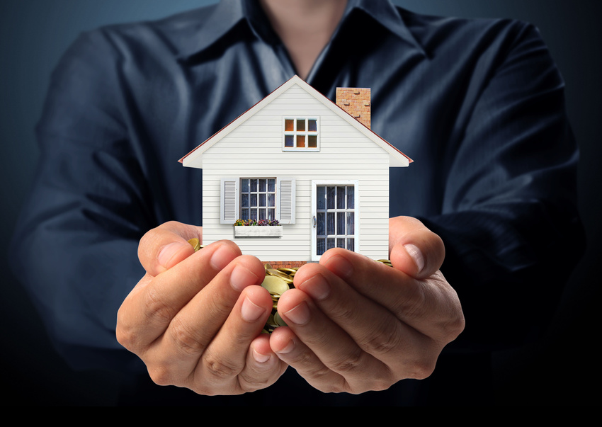 Photo of hands outstretched with a model of a home held in them