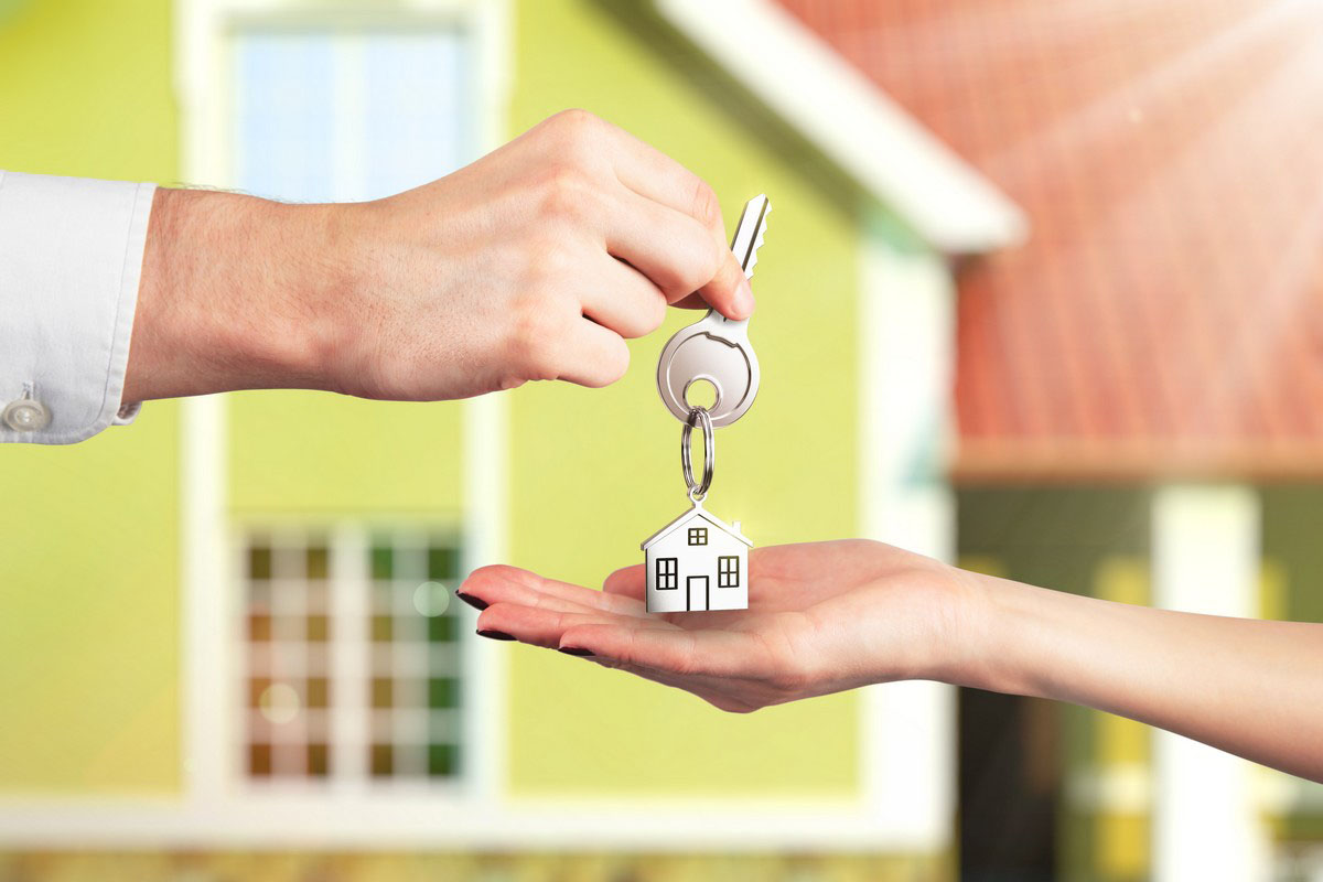 A photo of a person handing a house key to another person