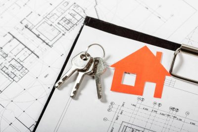 photo of a set of keys on a table on top of a home's blueprint drawings