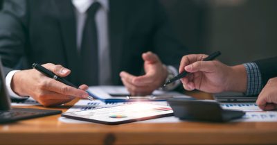 Business men working though financial graphics